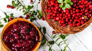 Preiselbeerenmarmelade neben frischen Preiselbeeren auf einem Tisch