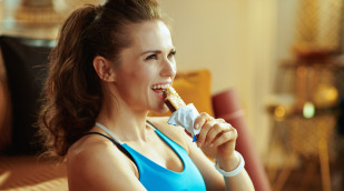 Sportlerin isst Proteinriegel