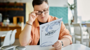 Mann liest Speisekarte in einem Restaurant