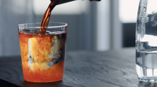 Sirup wird in ein Wasserglas gegeben