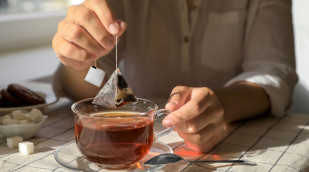 Mann nimmt einen Teebeutel aus der Tasse