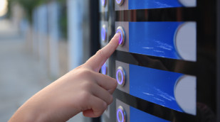Hand drückt Automatenknopf