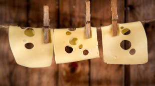 Emmentaler Käse hängt an einer Wäscheleine