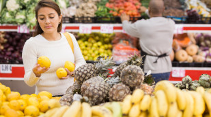 Verbraucherin begutachtet Obst