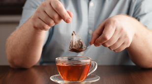 Teebeutel und Teetasse mit Person Teebeutel und Teetasse mit Person