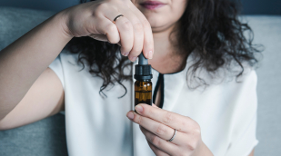 Frau, die cbd-Tropfen hält