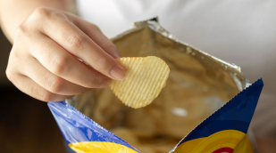 Hand mit Tüte und Kartoffelchips Hand mit Tüte und Kartoffelchips