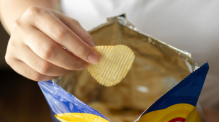 Hand mit Tüte und Kartoffelchips