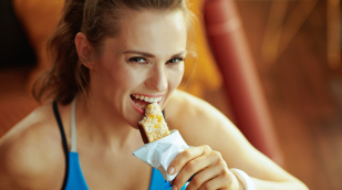 Sportlerin isst Proteinriegel