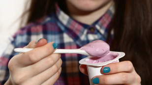 Person isst Fruchtjoghurt