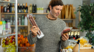 Mann vergleicht Produkte, die er in der Hand hält