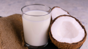 ein Glas mit Kokosmilch mit Kokosnuss