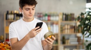 Mann mit Smartphone betrachtet ein Produkt